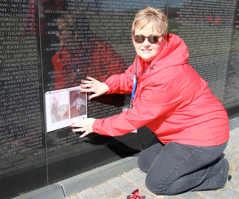 woman with picture at Vietnam memorial