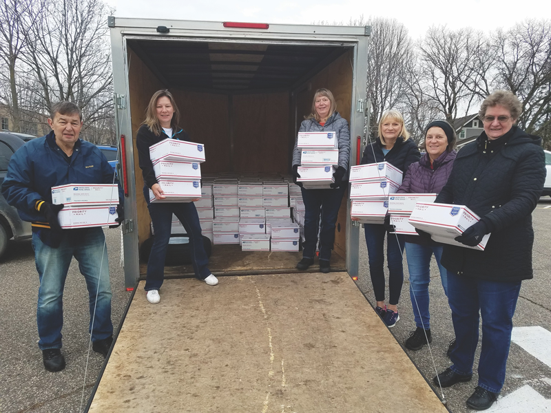 Members of a unit holding care packages at back of truck